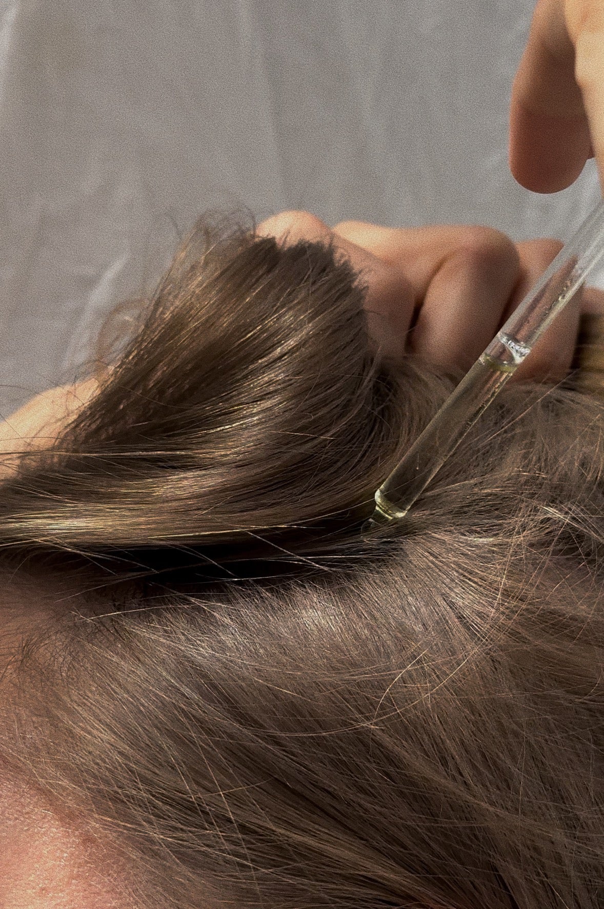 Woman applying rosemary oil to scalp for hair growth treatment