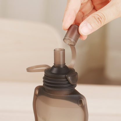 Opening dustproof cap on silicone baby food pouch showing leak-proof spout design