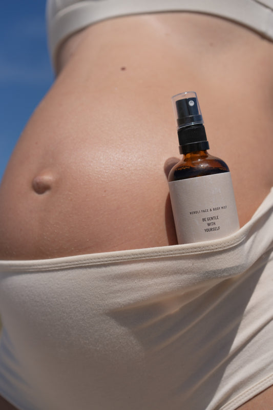 Neroli face mist held against pregnant belly for soothing pregnancy-safe hydration