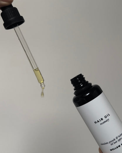 Rosemary hair oil with glass dropper dispensing nourishing oil for scalp and hair health