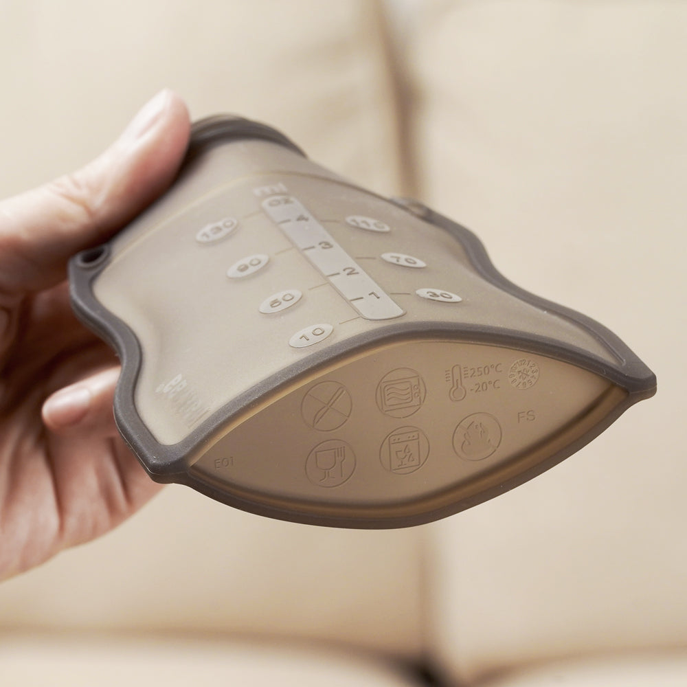 Flexible silicone food pouch showing measurement markings and temperature-safe material icons
