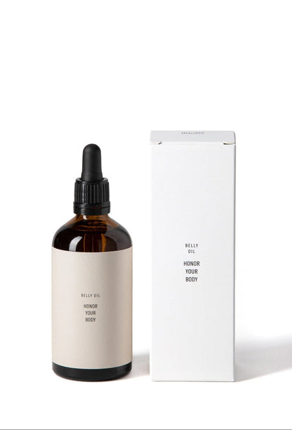 Brown glass bottle with belly oil and beige label next to a white rectangular box on a white background