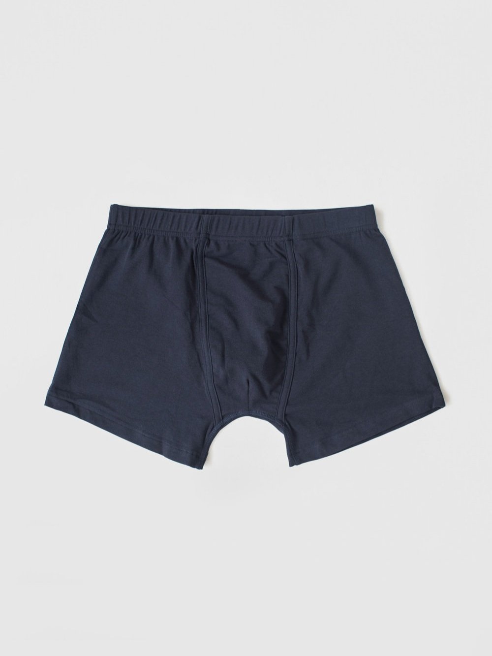 A pair of navy blue boxer briefs laid flat against a light gray background.