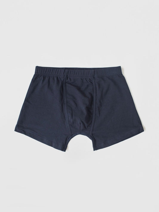 A pair of navy blue boxer briefs laid flat against a light gray background.