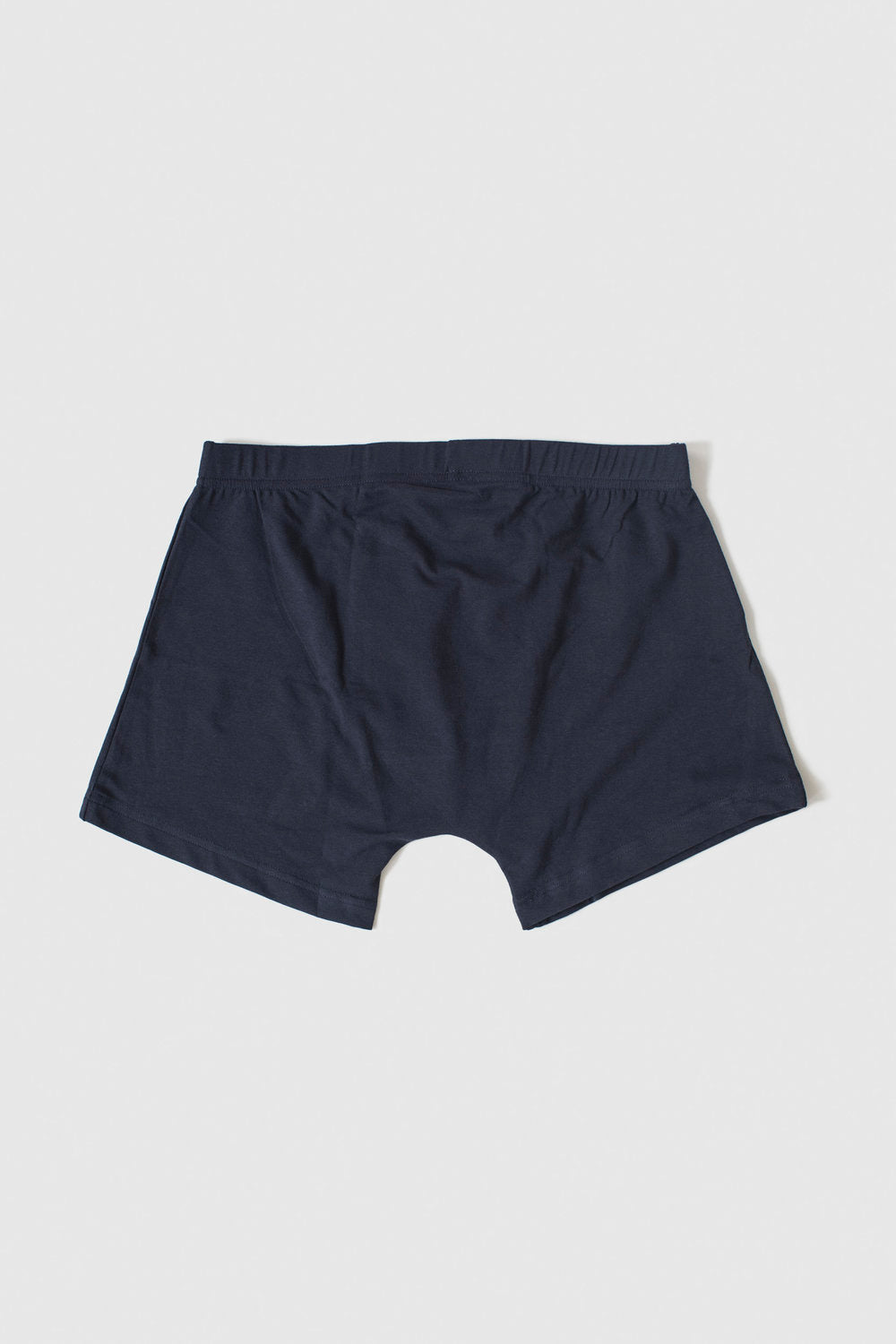 A pair of dark navy blue boxer briefs shown flat against a light gray background.
