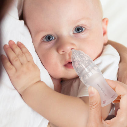 Parent using baby nasal aspirator for safe gentle mucus removal