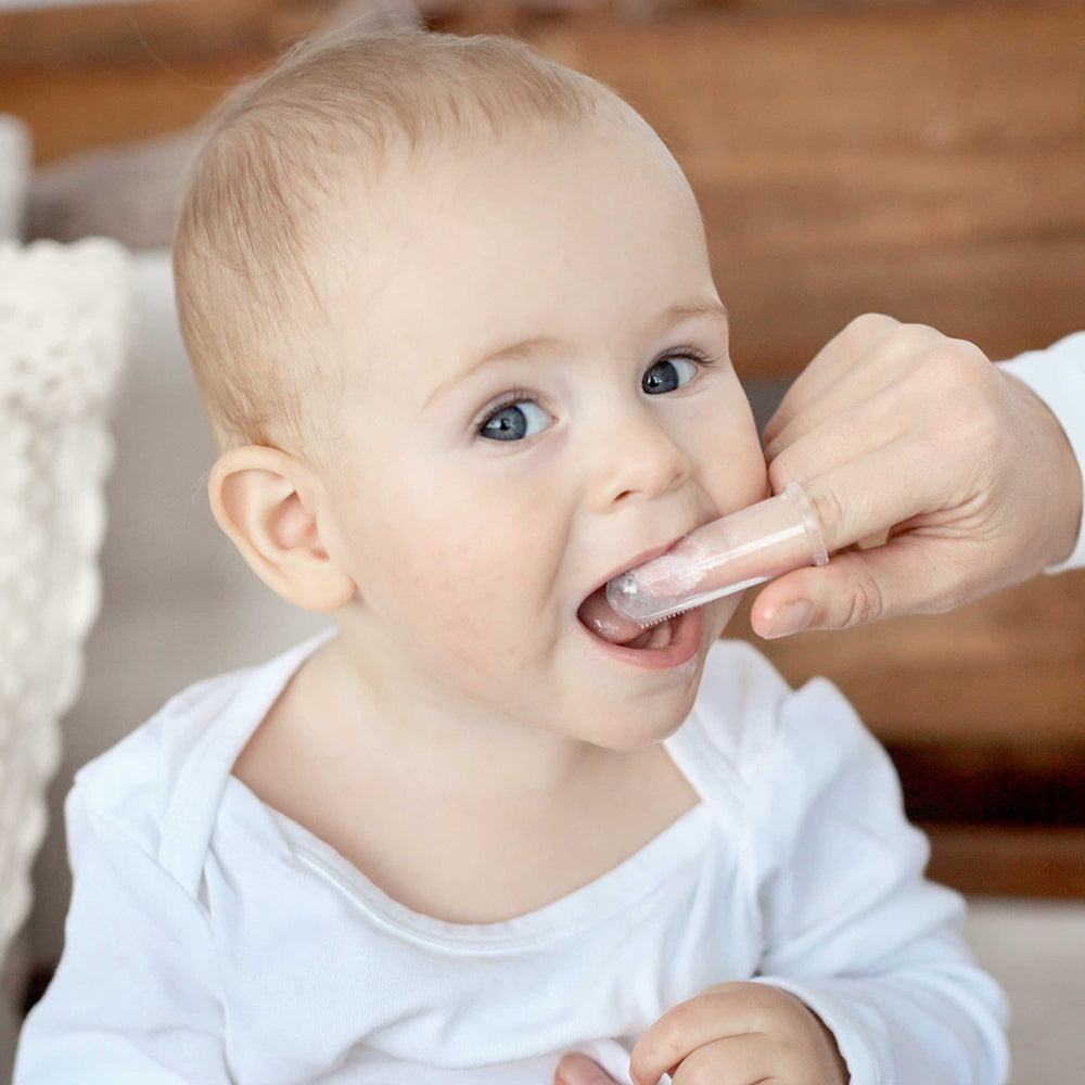 Baby oral care with gentle silicone finger brush for teething infants