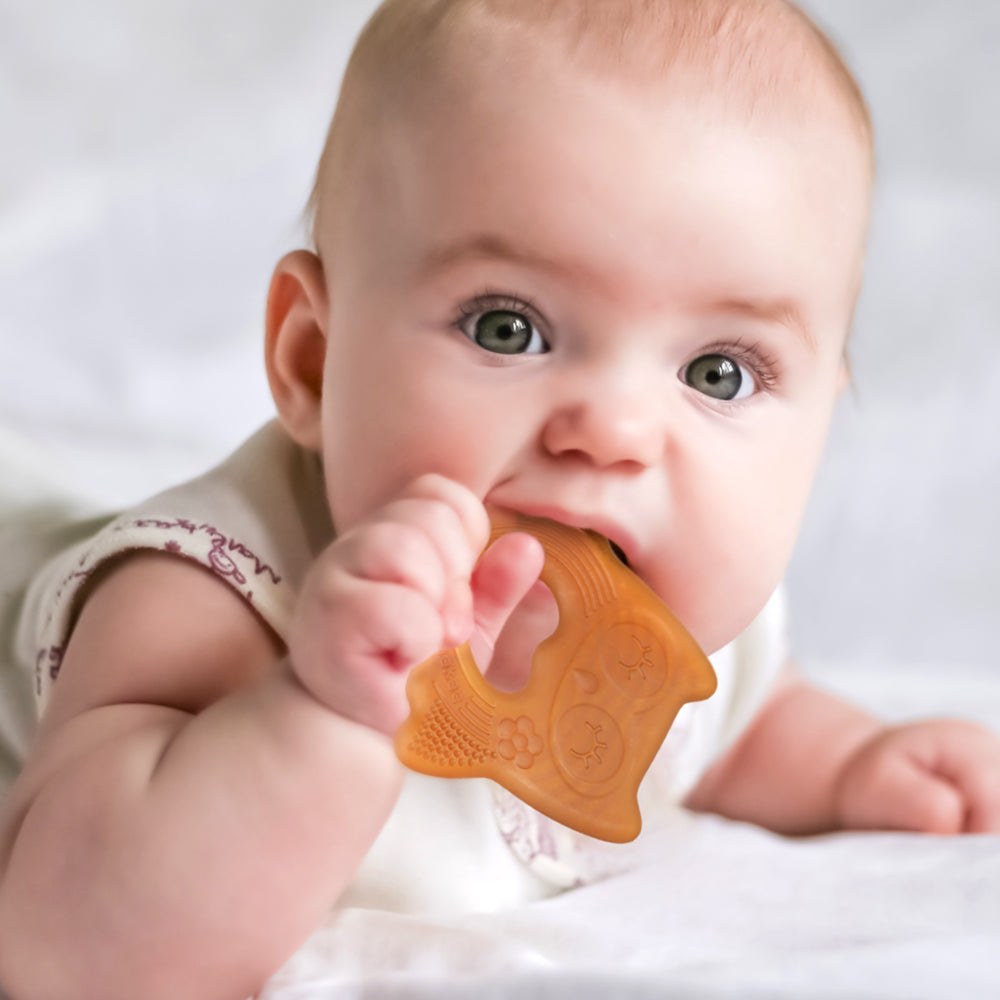 Baby using silicone owl teether for soothing teething pain relief
